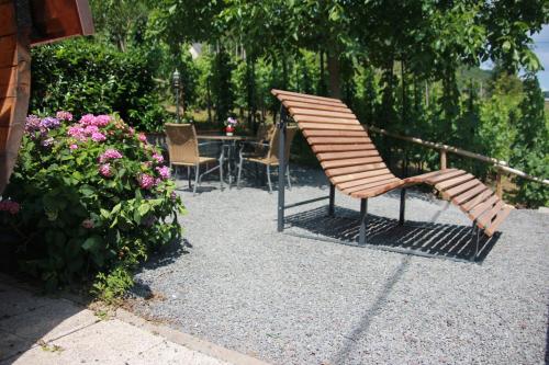 a wooden chair sitting next to a table and flowers at Weingut Schumacher - mit privatem Saunabereich in Sankt Aldegund