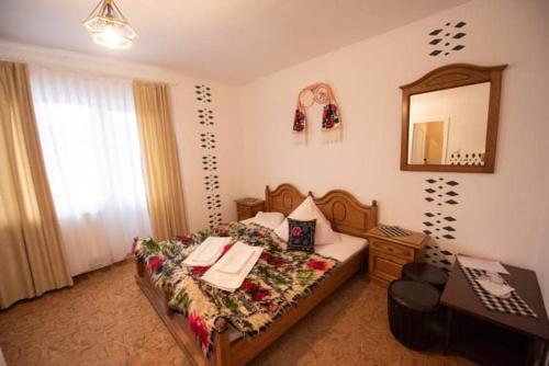 Ένα ή περισσότερα κρεβάτια σε δωμάτιο στο Pensiunea Casa Mariuca