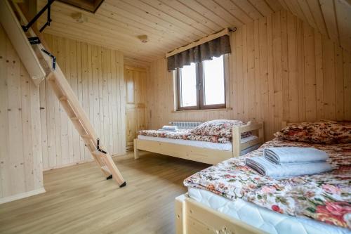 - une chambre avec 2 lits dans une maison en bois dans l'établissement Domek na Bachledówce, à Czerwienne