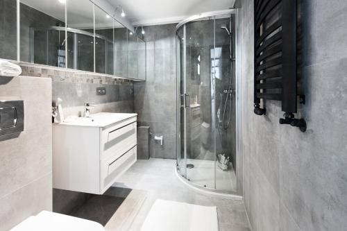 y baño con ducha y lavamanos. en SuperApart Rakowiecka 43a, en Varsovia