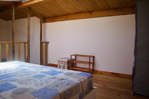 a bedroom with a bed and a chair in it at Casa THE NEST - Il Nido sul Mare in Badesi