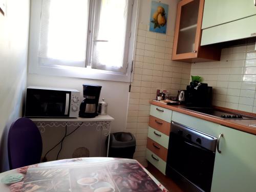 une petite cuisine avec une table et un micro-ondes dans l'établissement Résidence du Casino, à Menton