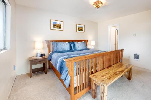 a bedroom with a wooden bed and a wooden bench at Tidal Links - 4 Bed 3 Bath Vacation home in Bandon Dunes in Bandon