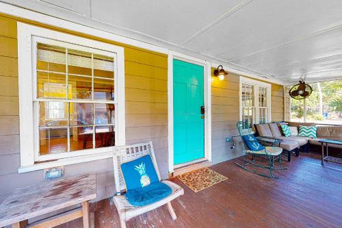 a porch of a house with a couch and chairs at Cozy Corner in Folly Beach