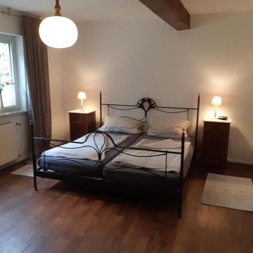 1 dormitorio con 1 cama negra y 2 mesitas de noche en Am Hohestein, en Briedeler Heck