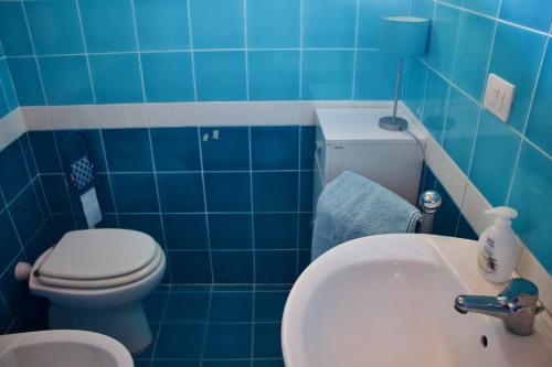 a blue bathroom with a toilet and a sink at Casa THE NEST - Il Nido sul Mare in Badesi
