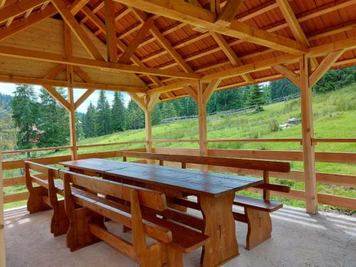 a wooden picnic table and benches in a pavilion at Casa Bogdan in Vartop