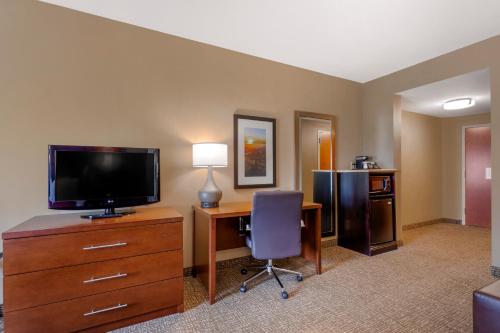 a hotel room with a desk with a tv and a computer at Comfort Suites Knoxville North in Knoxville