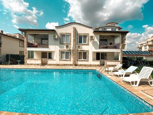 a villa with a swimming pool in front of a house at Complex Sea & Sky next to the Beach ! in Kranevo