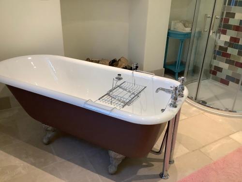 a bath tub sitting in a bathroom with a shower at Garden apartment in Weston-super-Mare