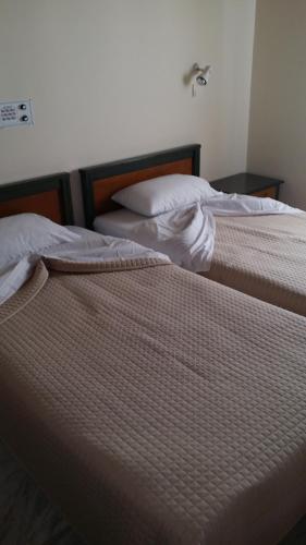 two beds sitting next to each other in a bedroom at Mythos Beach Hotel Apartments in Maleme