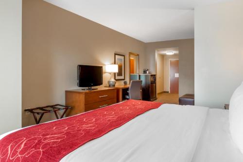a hotel room with a bed and a flat screen tv at Comfort Suites Knoxville North in Knoxville