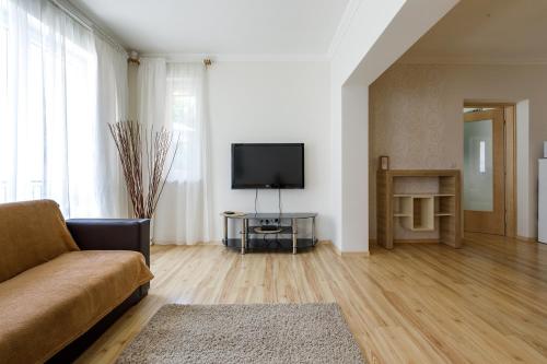 a living room with a couch and a flat screen tv at Andi Apartman in Hévíz