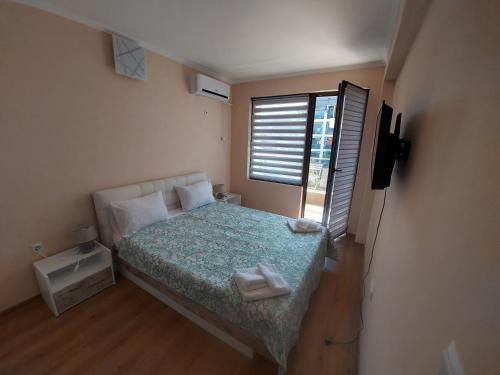 um quarto com uma cama com duas toalhas em До морето em Burgas