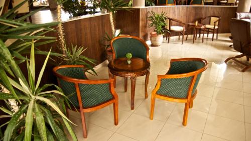 three chairs and a table with a vase on it at Boutique Hotel L do Rado in Sofia