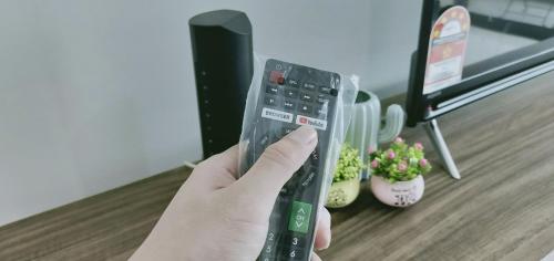 a person holding a remote control in a room at ABHOME "JAPAN SUITE" #GreenHaven #Olympic Pool #360"SeaView #JB in Johor Bahru