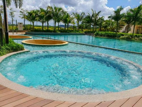 a large pool with blue water and palm trees at ABHOME "JAPAN SUITE" #GreenHaven #Olympic Pool #360"SeaView #JB in Johor Bahru