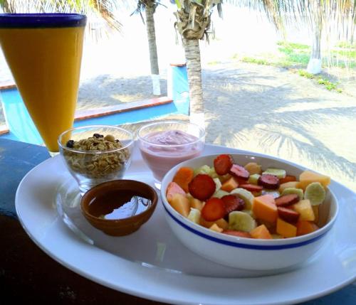 a plate of food with a bowl of fruit and a drink at Dulce y Salado in La Curbina