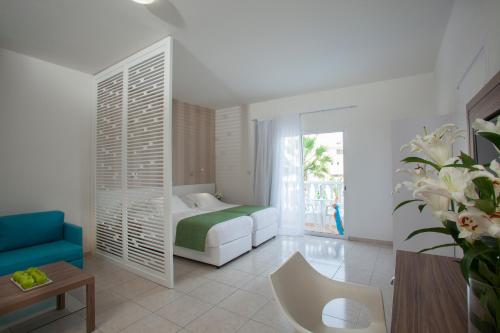a bedroom with a bed and a couch and a table at Princessa Vera Hotel Apartments in Paphos