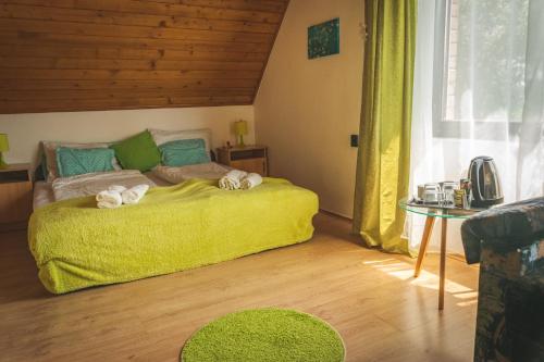 a bedroom with a green bed with towels on it at Linett Apartman in Hajdúszoboszló