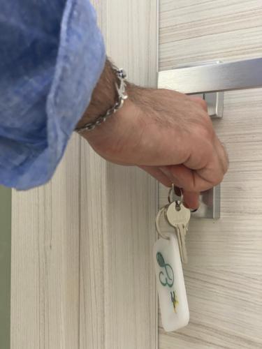 a person unlocking a door with a key at B&B Barù in Agropoli