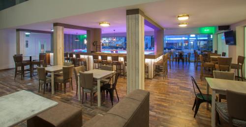a restaurant with tables and chairs and a bar at Princessa Vera Hotel Apartments in Paphos