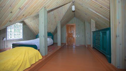a attic bedroom with a bed and a wooden ceiling at Эко-дом в горах in Ch'aisubani