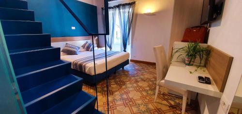 a room with a bed and a table and a staircase at Duomo Attic (rooms) in Ravello