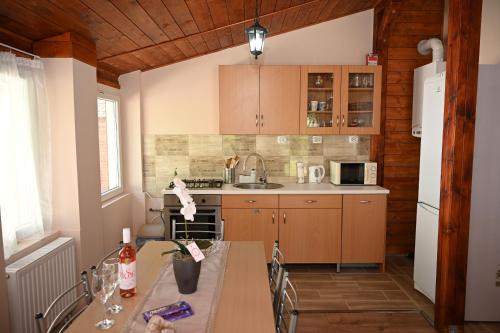 una pequeña cocina con mesa y fregadero en Pálma Apartman, en Gyula