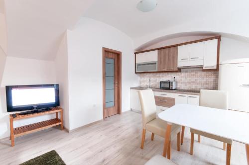 a kitchen and dining room with a table and a tv at The Maze Apartment in Ljubljana