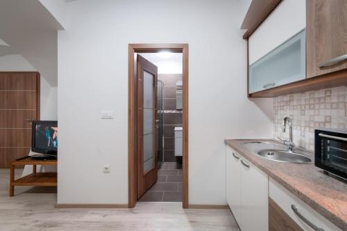 a kitchen with a sink and a mirror at The Maze Apartment in Ljubljana