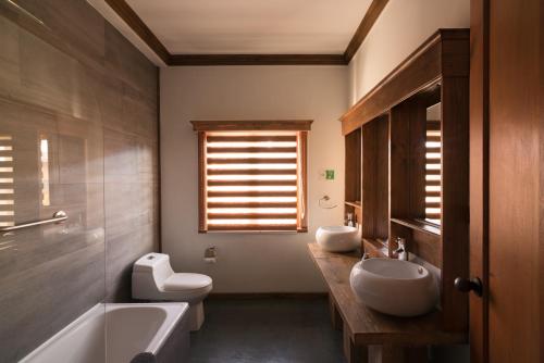a bathroom with two sinks and a toilet and a tub at Esencia Hotel Boutique in Viña del Mar