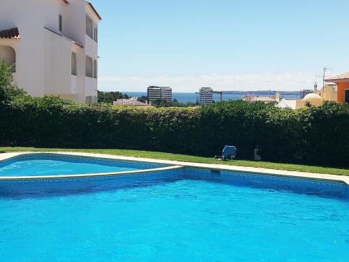 a large blue swimming pool next to a building at Amoreira Mar, Alvor - Praia e Piscina in Alvor