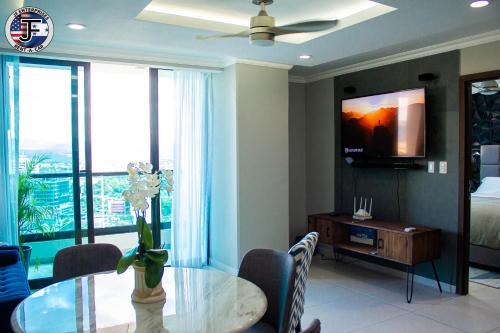 Un comedor con una mesa y un televisor. en JF Apartments, en Tegucigalpa
