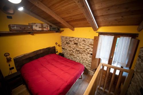 um quarto com uma cama vermelha num quarto em Casa vacanze I Foresti Ca' Ciota em Cartignano