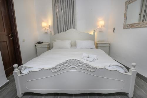 a white bed in a bedroom with two towels on it at Shirat Hayam Boutique Hotel in Tiberias