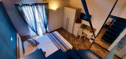a bedroom with a bed and a desk and a window at Duomo Attic (rooms) in Ravello