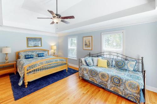 a bedroom with two beds and a ceiling fan at Chateau Relaxo in Edisto Beach