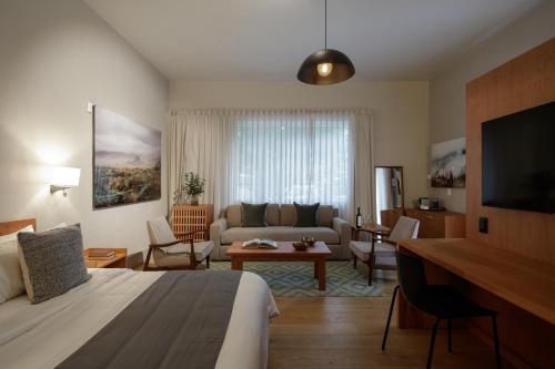 ein Hotelzimmer mit einem Bett und einem Wohnzimmer in der Unterkunft Casa Bosque Eduviges in Guadalajara