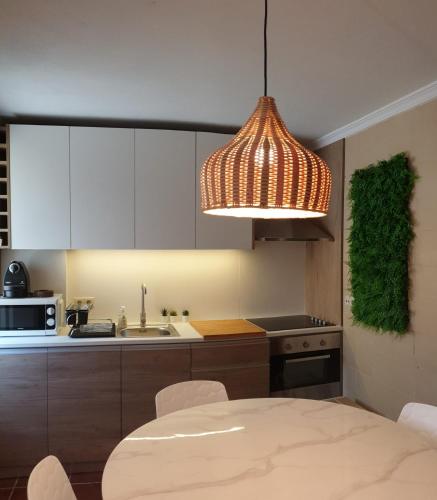 a kitchen with a table and a light fixture at Vivenda Oliveira - Alojamento Local in Lamego
