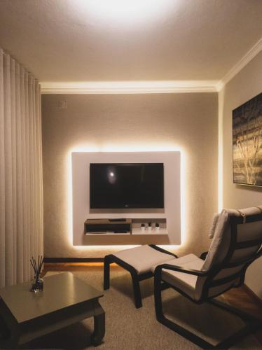 a living room with a television on a wall at Vivenda Oliveira - Alojamento Local in Lamego