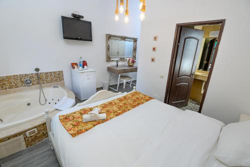 a bedroom with a bed and a tub and a sink at Shirat Hayam Boutique Hotel in Tiberias