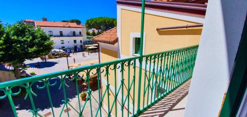 a balcony with a green railing next to a building at Duomo Attic (rooms) in Ravello