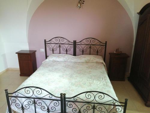 a bedroom with a bed with a metal bed frame at Agriturismo Tenuta Perruzzi in Leverano