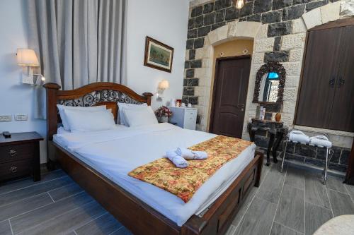 a bedroom with a bed with two towels on it at Shirat Hayam Boutique Hotel in Tiberias