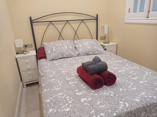 een slaapkamer met een bed met rode en grijze dekens bij TURISSTIKO La Roca Chica 2 in Torremolinos