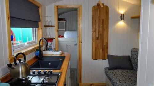 a kitchen with a stove and a sink and a kitchen with a couch at Unique Upcycled Straw Trailer Westcote in Hawick