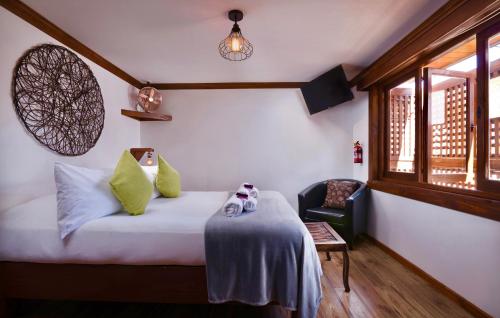 a bedroom with a bed and a chair and a window at Esencia Hotel Boutique in Viña del Mar