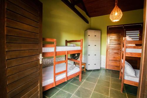 Habitación con 3 literas y puerta en Hostel La Isla, en Pipa