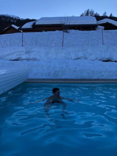 un garçon nageant dans une piscine avec neige dans l'établissement Skis aux pieds station 1800 Dame Blanche, à Puy-Saint-Vincent